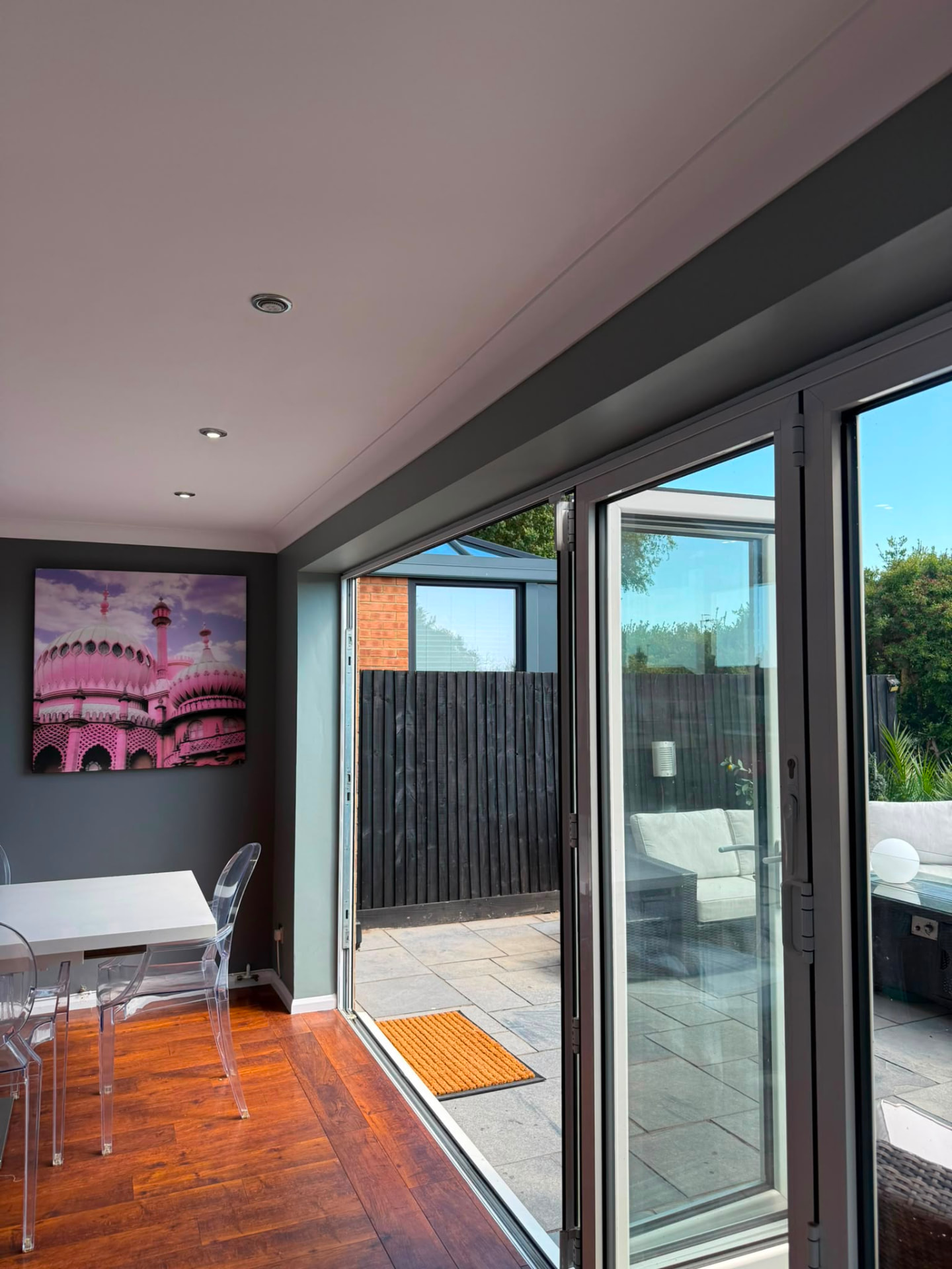 Crisp white bi-fold door reveals and painted woodwork leading to a patio, Brighton
