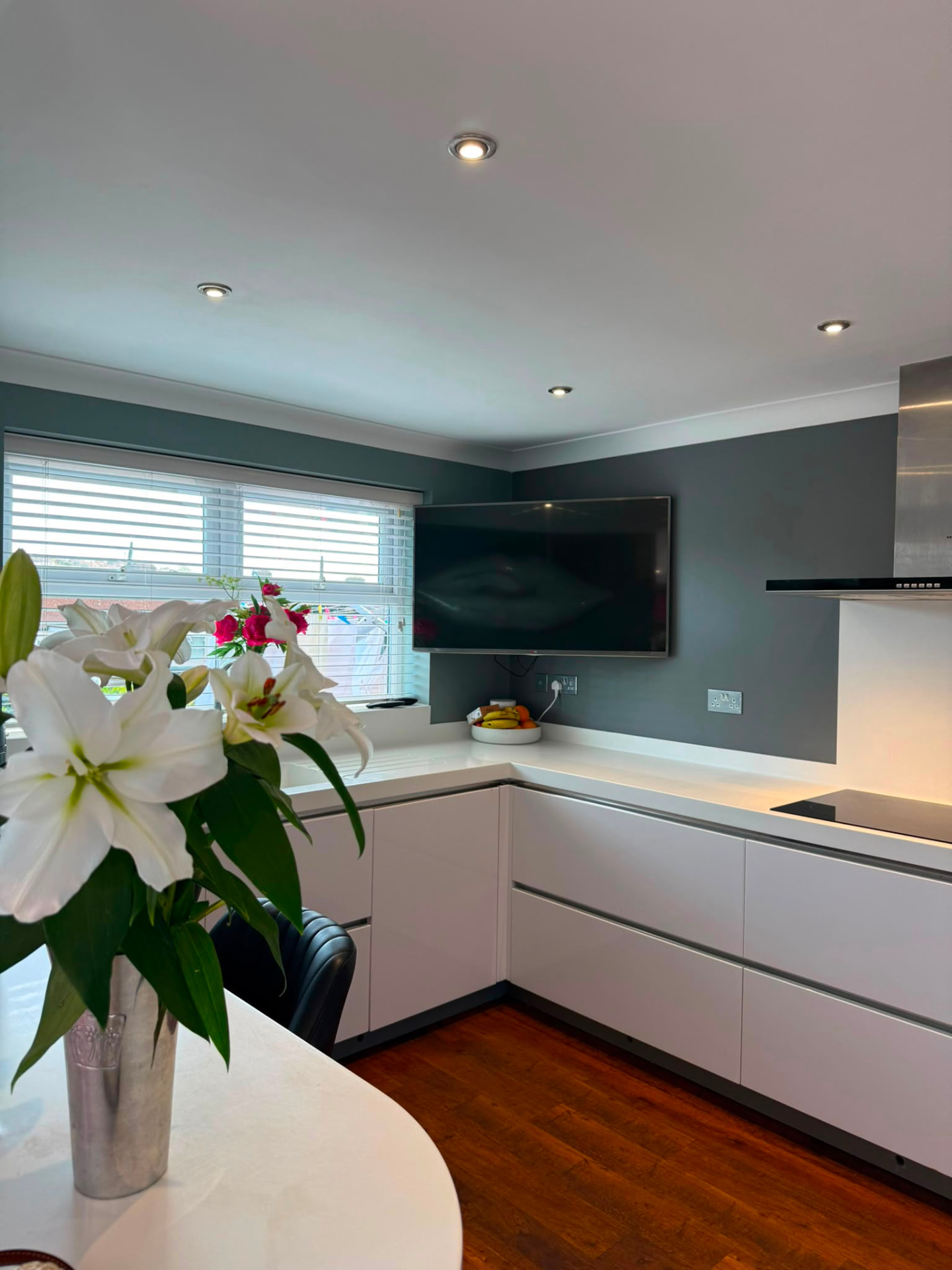 Family kitchen finished in blue-grey emulsion with natural light from a side window, Hove