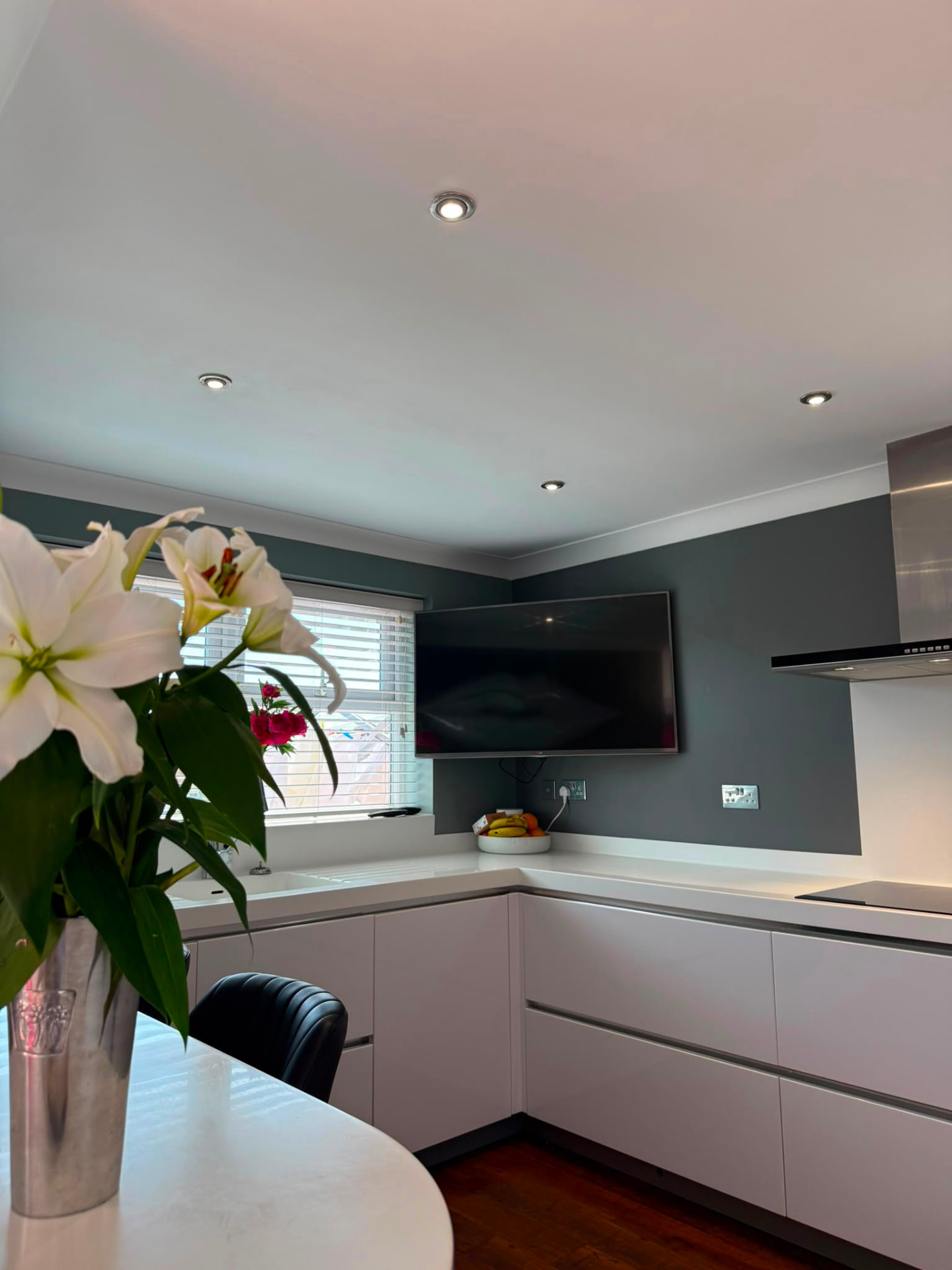 Kitchen corner with soft slate walls, wall-mounted television and white lilies, Brighton