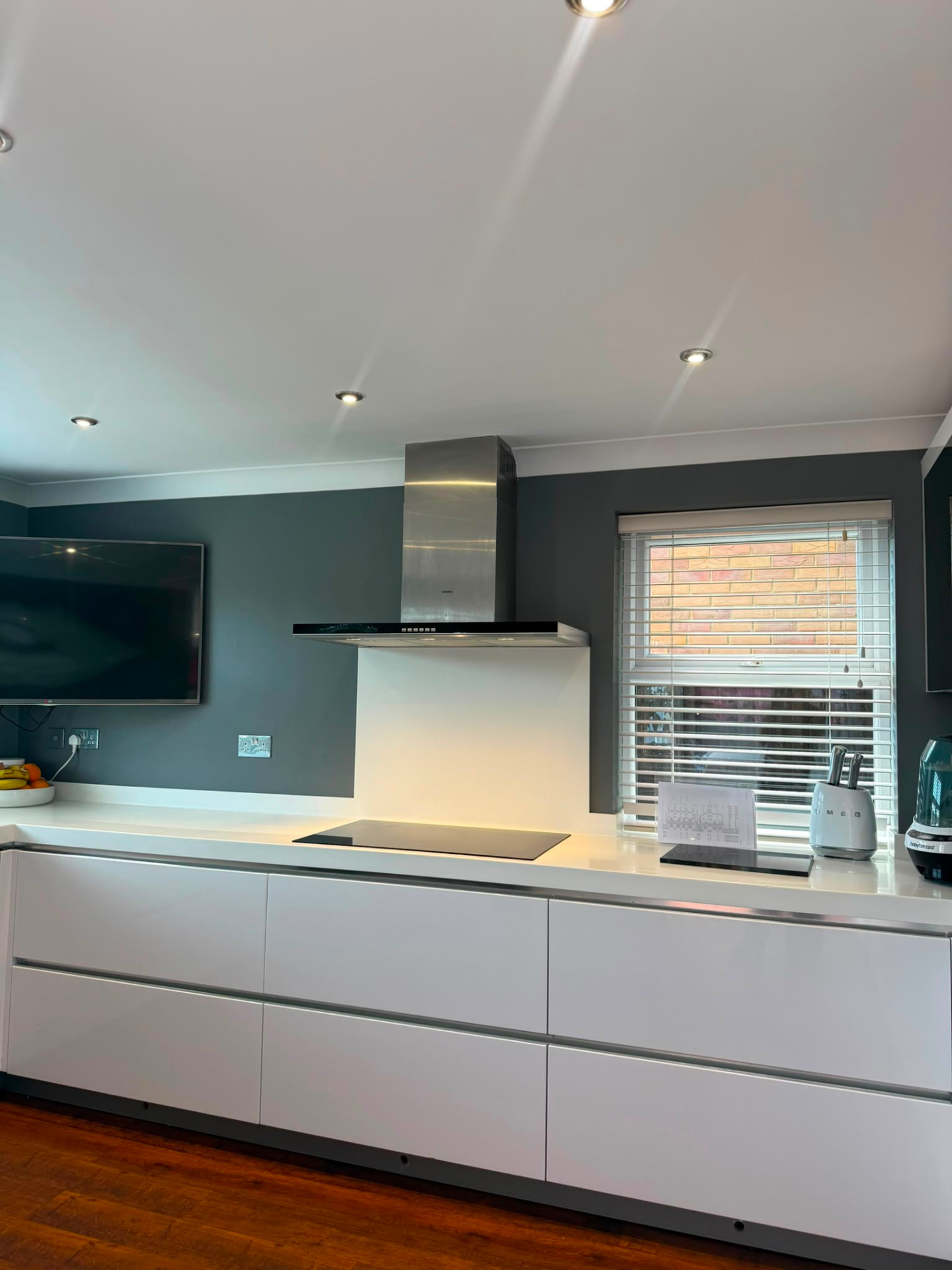 Dining room with soft charcoal walls, white table and framed canvases, Hove