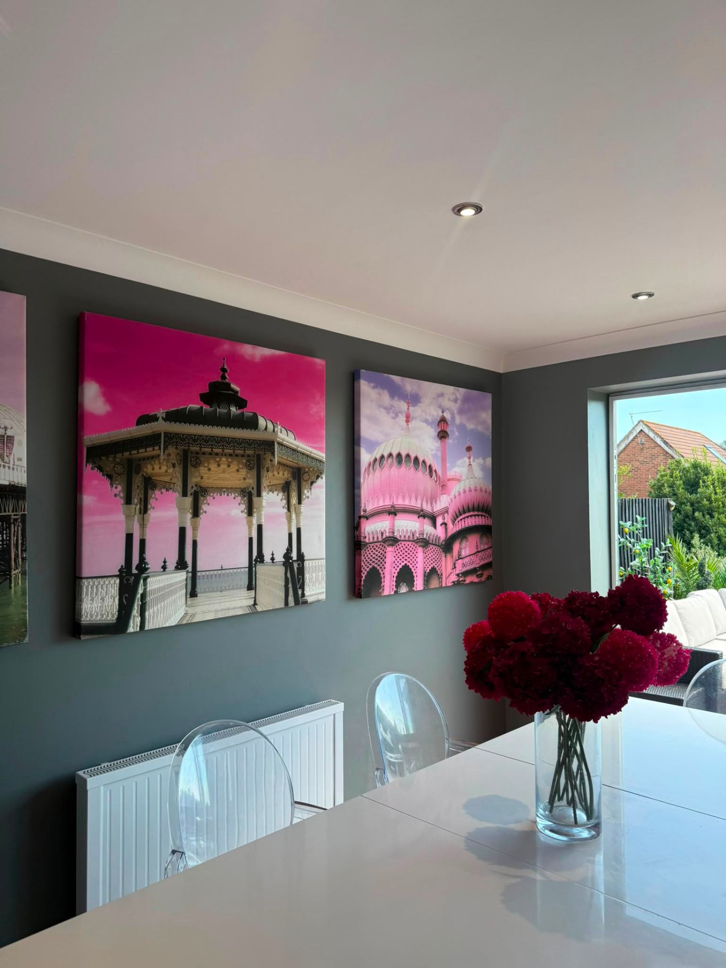 Deep graphite dining wall with artwork, clear chairs and a white table, Hove
